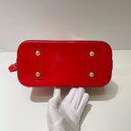 the bottom view of authentic preloved louis Vuitton alma bb bag with gold studs at corners in excellent condition