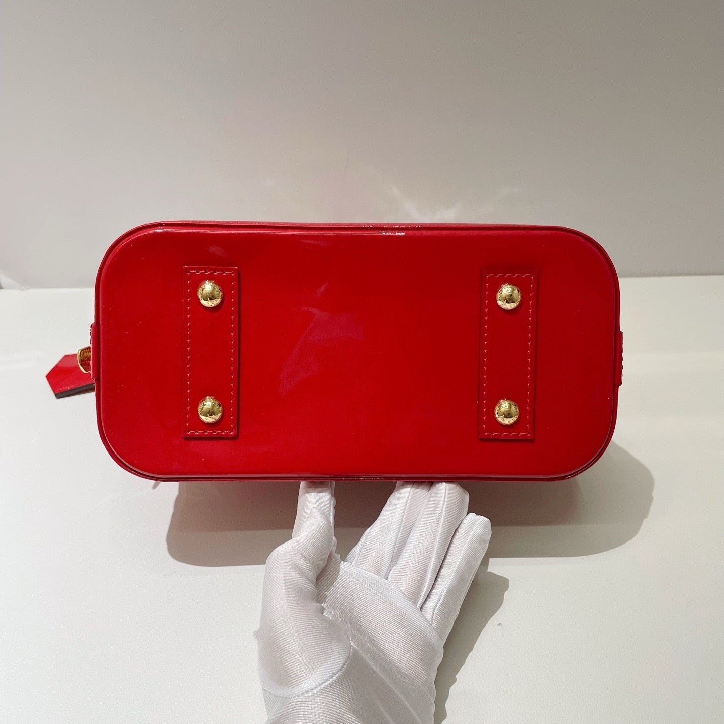 the bottom view of authentic preloved louis Vuitton alma bb bag with gold studs at corners in excellent condition