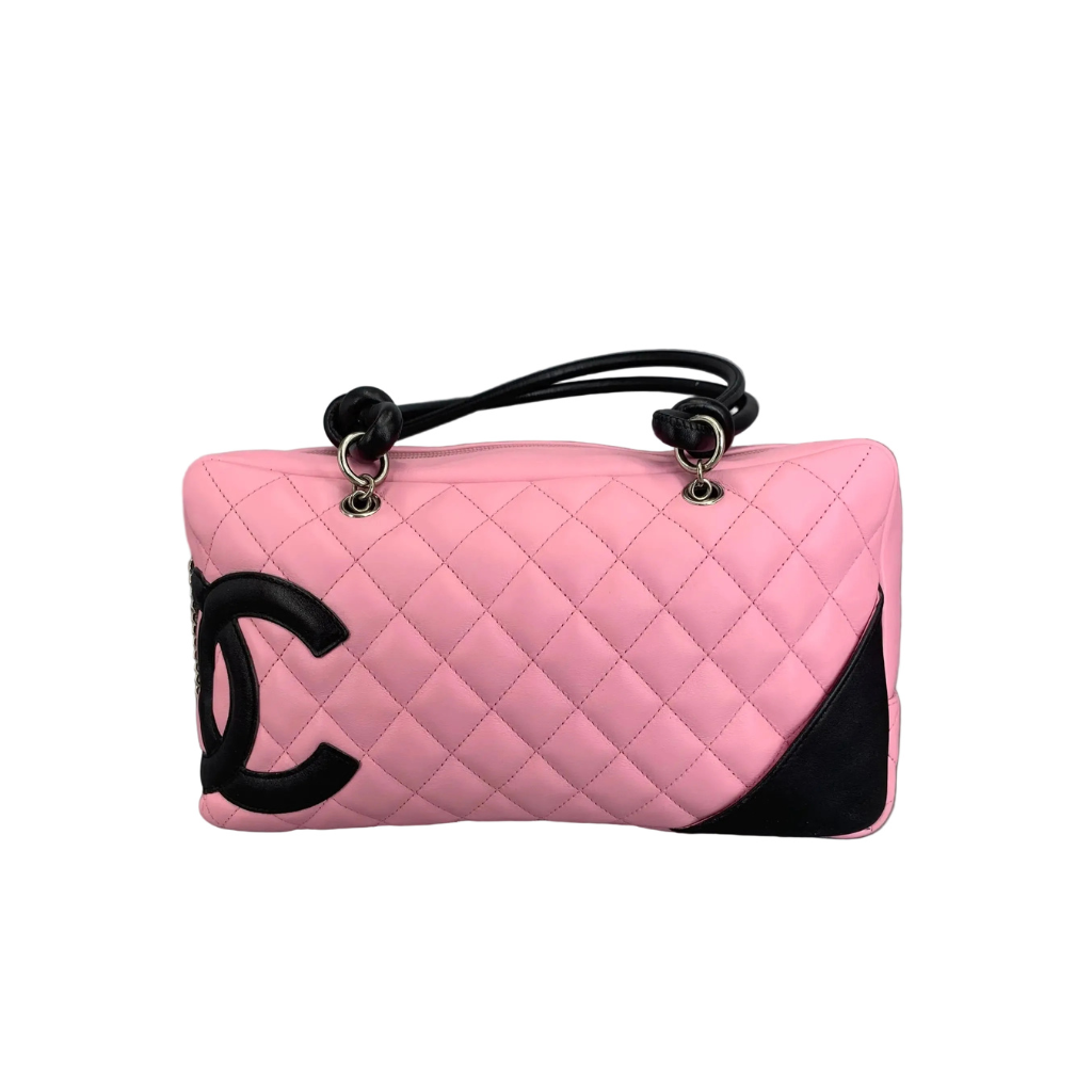 Side view of an authentic Chanel Cambon Ligne Bowler Bag in pink quilted leather with large black CC logo.