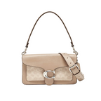 A Coach shoulder bag in beige and taupe leather with the brand's signature monogram pattern, a silver-tone 'C' logo clasp, and a matching adjustable shoulder strap, shown against a light gray background.