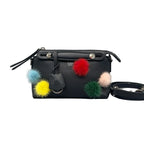 Front view of a black Fendi Mini By The Way bag featuring multicolored fur pom-poms, collapsible top handles with silver studs, and a detachable shoulder strap on a white background.
