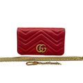 Front view of an authentic Gucci GG Marmont Super Mini bag in red chevron quilted leather with antique gold-tone GG logo and detachable chain strap on a white background.