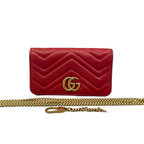 Front view of an authentic Gucci GG Marmont Super Mini bag in red chevron quilted leather with antique gold-tone GG logo and detachable chain strap on a white background.