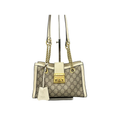 Front view of a Gucci Padlock Medium Shoulder Bag in GG Supreme canvas with white leather trim and gold hardware on a display stand.