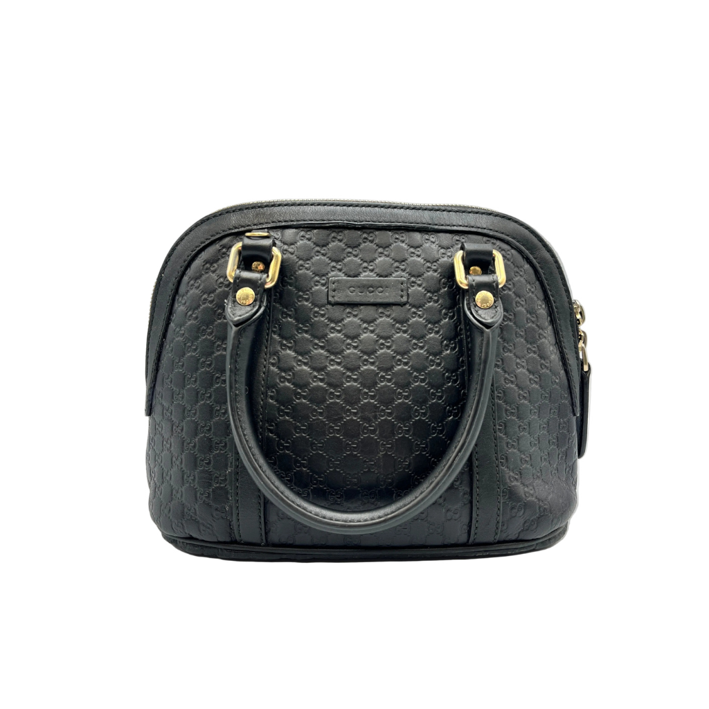 Black textured handbag with gold accents on a white background