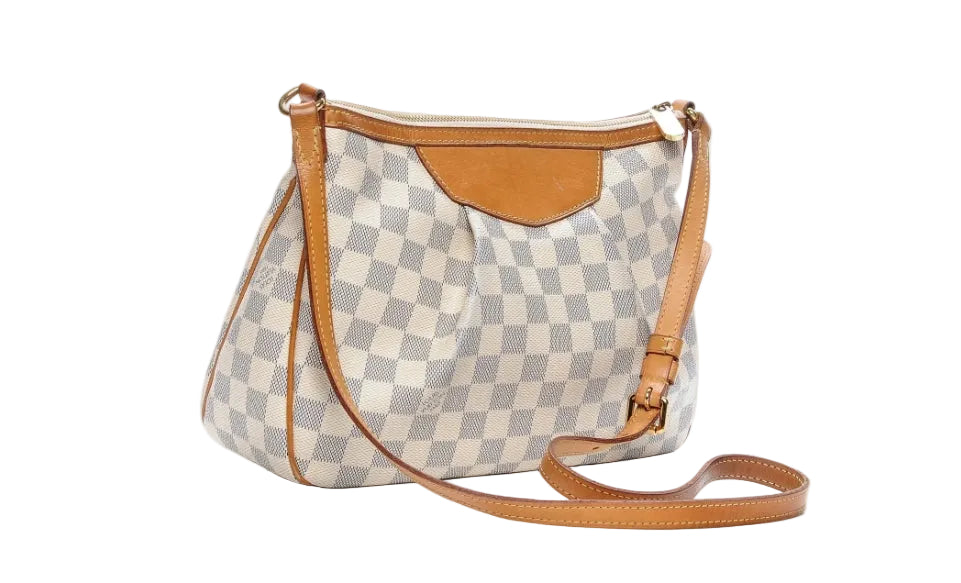 side view of preowned lv shoulder bag in great condition with classic damier azur and light brown vachetta leather strap