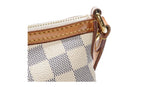 Close-up of a checkered louis vuitton handbag with brown vachetta leather accents in very good condtion