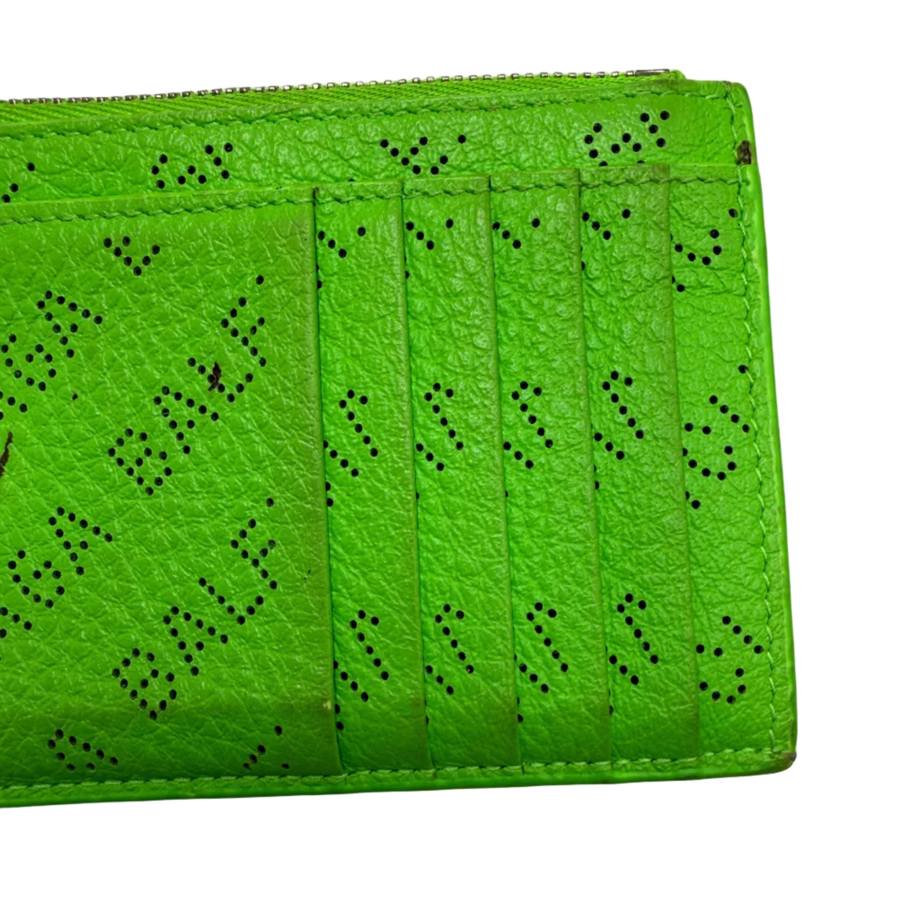 A bright lime green textured leather wallet with black perforated lettering spelling 'BALENCIAGA' and multiple card slots, photographed on a plain white surface.