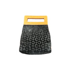 A small black handbag with a repeating monogram pattern and a bright yellow handle, shown against a plain white background.
