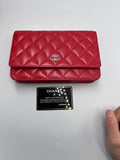 Front view of a Chanel Classic Wallet on Chain in red quilted lambskin leather with silver CC logo and authenticity card.
