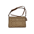 Front view of Coach East West Pop Up Messenger in brown Signature canvas with Saddle leather trim and adjustable strap.