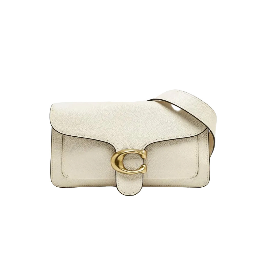 Front view of a white Coach Tabby 26 bag with gold C hardware and matching crossbody strap on a white dust bag.