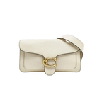 Front view of a white Coach Tabby 26 bag with gold C hardware and matching crossbody strap on a white dust bag.