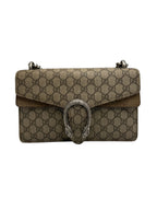A Gucci Dionysus shoulder bag in brown GG Supreme canvas with a silver-tone metal snake clasp, shown against a neutral gray background.