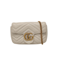 Beige quilted handbag with gold chain and logo on a white background