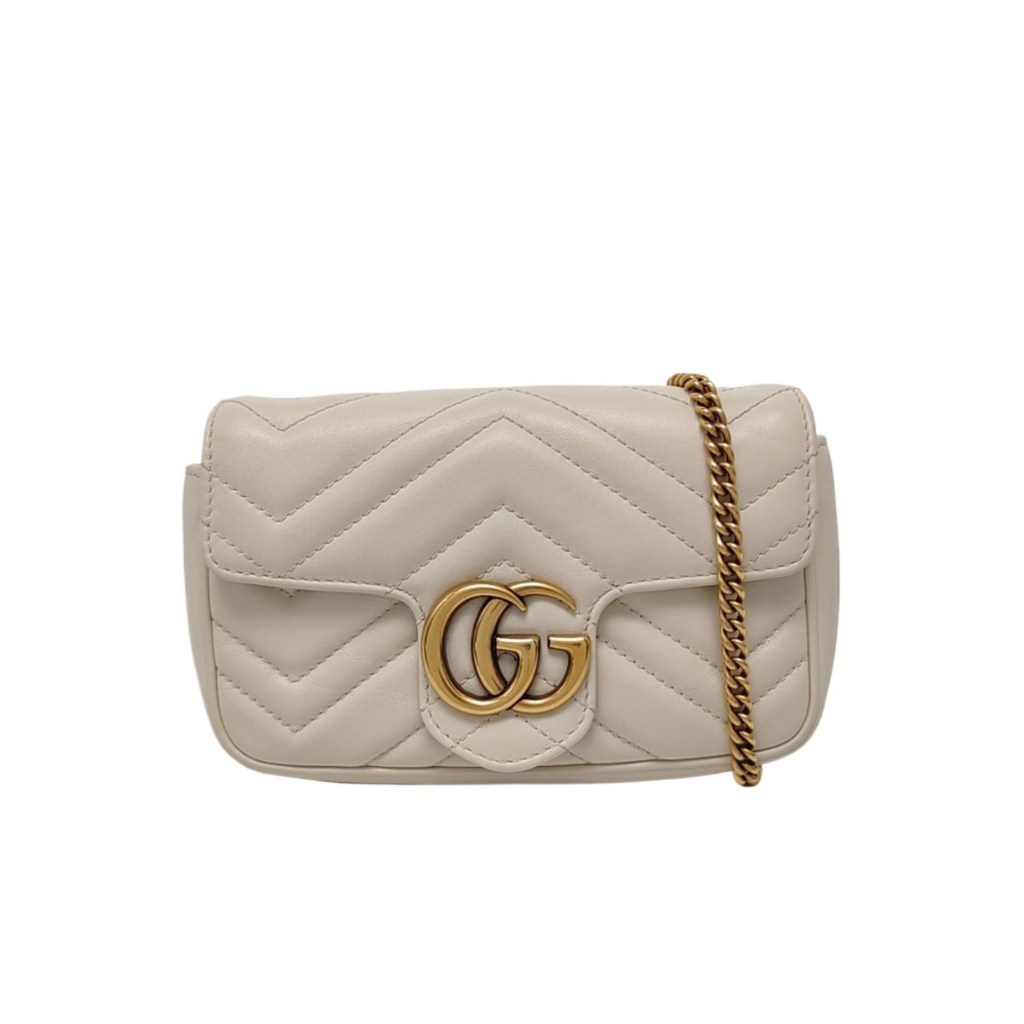 Beige quilted handbag with gold chain and logo on a white background