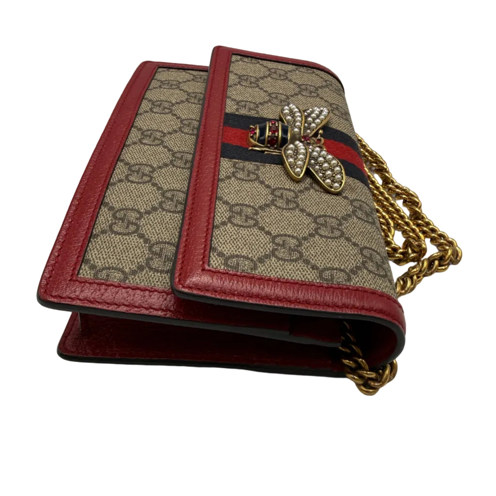 Designer handbag with bee emblem and chain strap