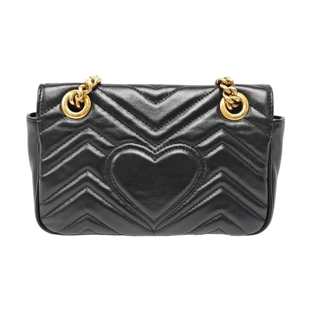 the back view of the gucci marmont small black leather bag and gold hardware in good condition with slight indentation 