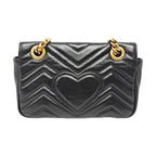the back view of the gucci marmont small black leather bag and gold hardware in good condition with slight indentation 
