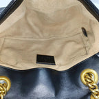 the inside of the gucci marmont small shoulder bag. interior is clean with a few marks and stain 