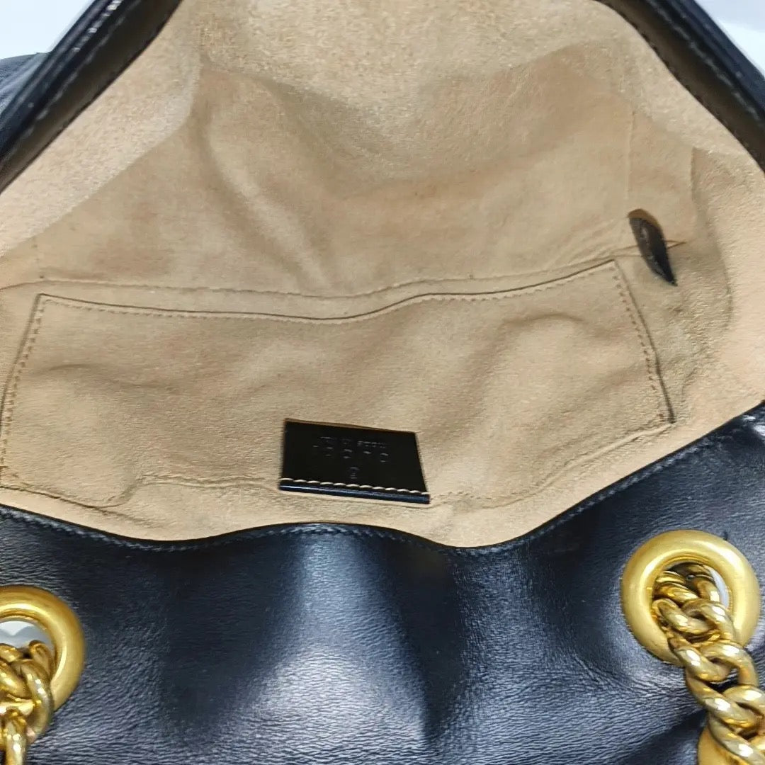 the inside of the gucci marmont small shoulder bag. interior is clean with a few marks and stain 