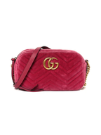 Front view of a Gucci GG Marmont small camera bag in fuchsia pink chevron quilted velvet with antique gold-tone Double G logo.