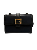 Front view of a vintage Gucci flap shoulder bag in black canvas and leather featuring a gold-tone Square G buckle