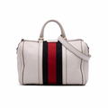 Front view of a white Gucci Joy Boston bag in GG Supreme leather with navy leather trim and a navy/red Web stripe.