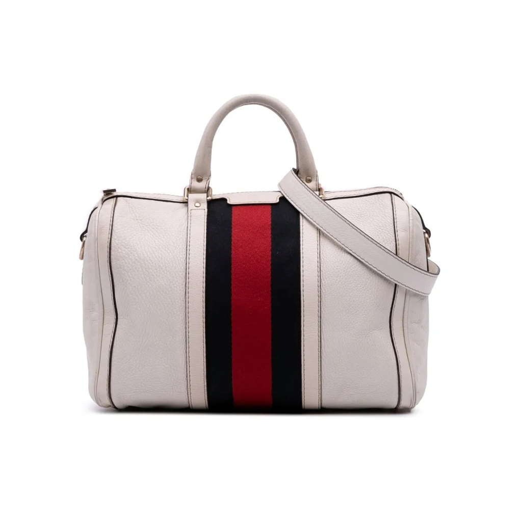 Front view of a white Gucci Joy Boston bag in GG Supreme leather with navy leather trim and a navy/red Web stripe.