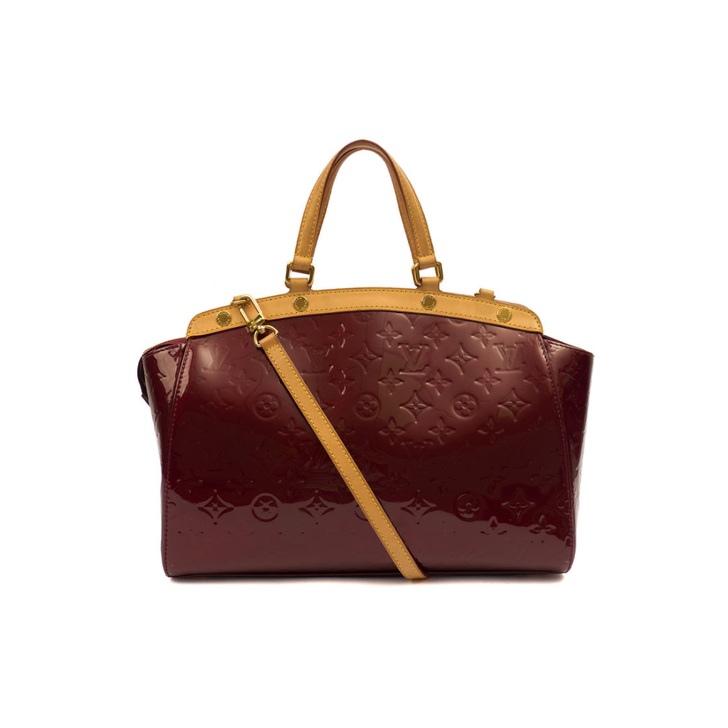Louis Vuitton monogrammed patent leather handbag in burgundy with tan leather handles and a matching shoulder strap, shown on a plain white background.