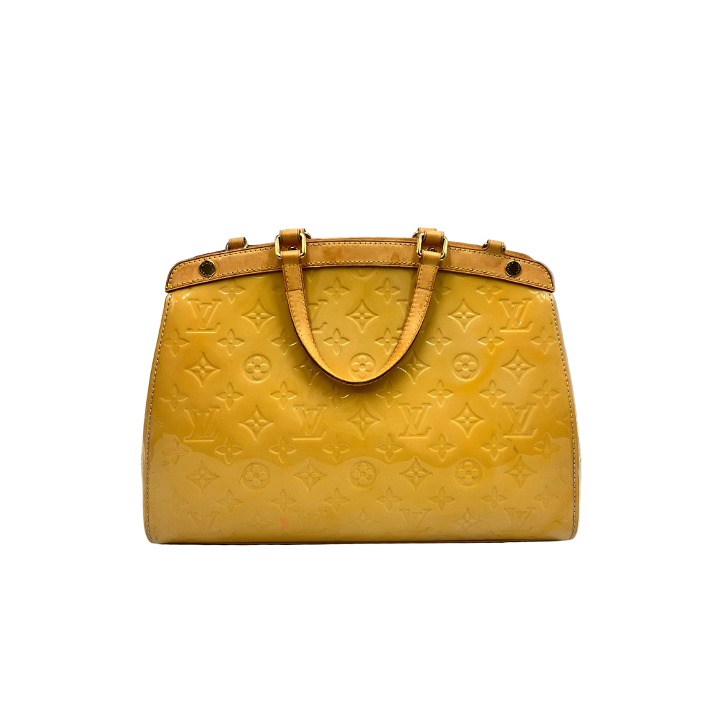 Front view of a Louis Vuitton Brea MM bag in glossy Amarante Monogram Vernis with tan leather handles.