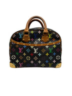 Front view of a Louis Vuitton x Takashi Murakami Monogram Multicolore Trouville bag in black canvas with brass corner guards and vachetta handles.