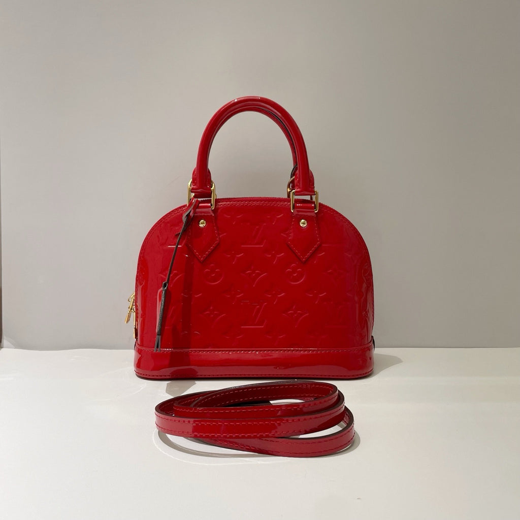 preowned louis Vuitton alma bb bag with removable strap in red patent leather and gold hardware in excellent condition front full view with monogram patten 