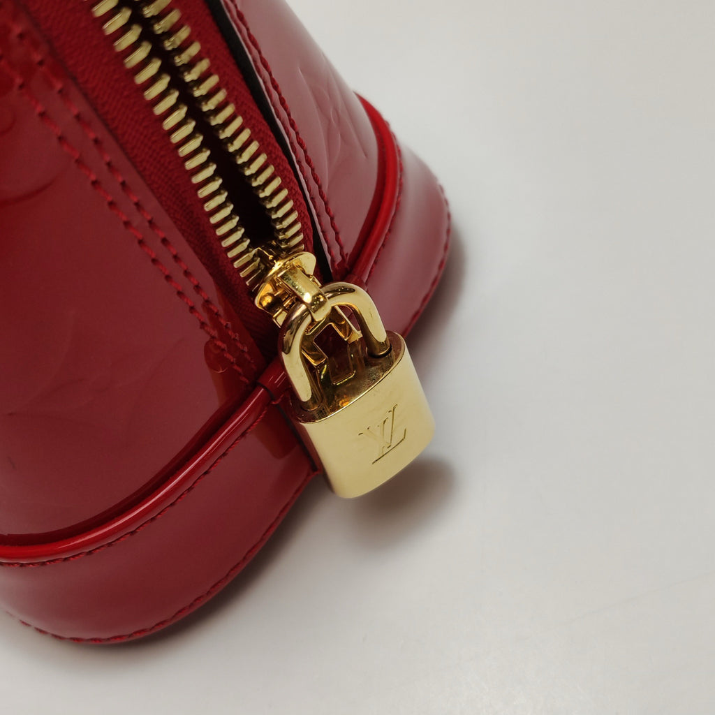 the gold lock hardware from authentic louis vuitton alma bb bag with lv logo engraving 