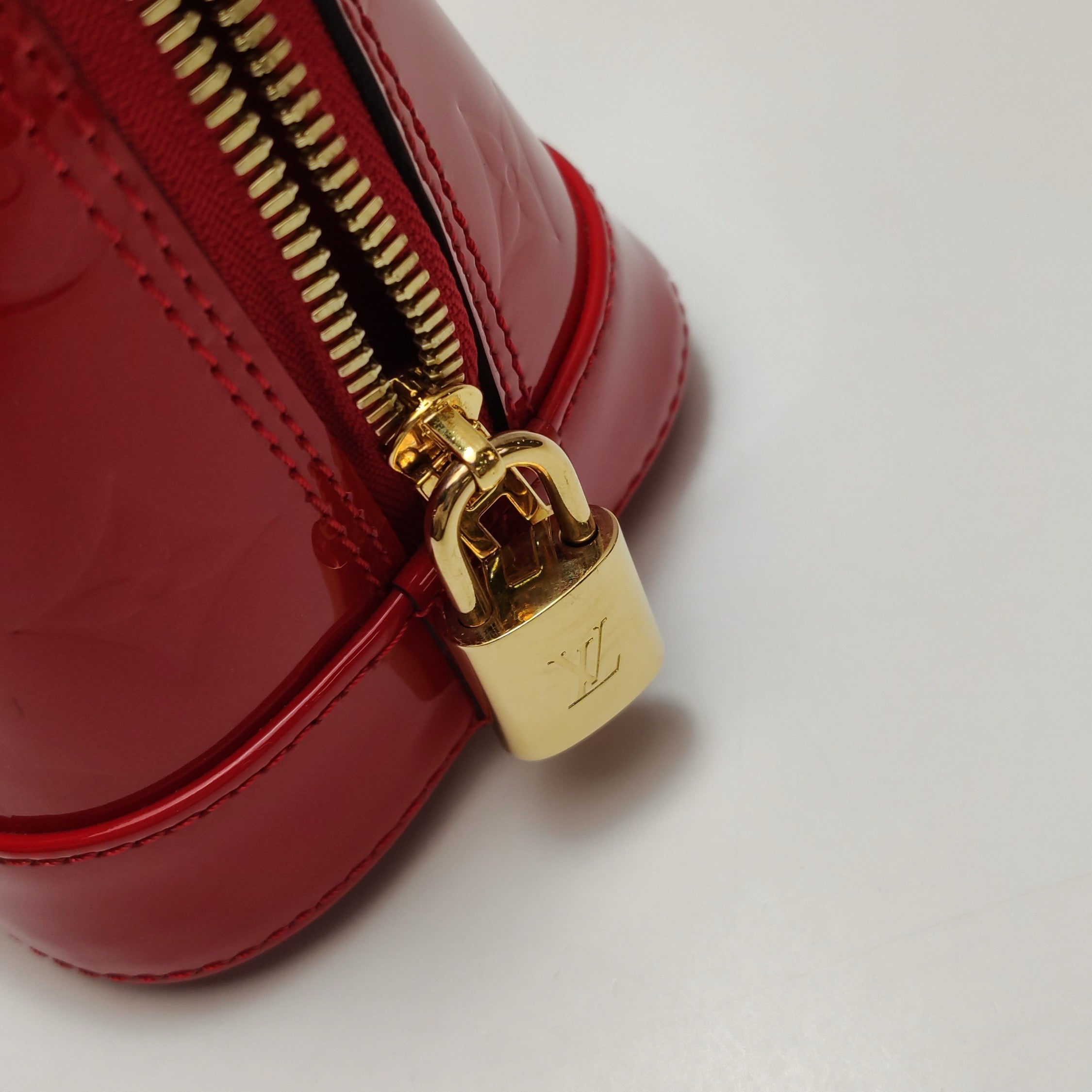 the gold lock hardware from authentic louis vuitton alma bb bag with lv logo engraving 