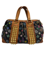 Louis Vuitton monogram canvas duffle bag with tan leather trim, gold-tone studs, and multicolor monogram motifs on a light gray background.