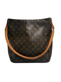 A Louis Vuitton monogram canvas shoulder bag in dark brown with tan leather trim and strap, photographed against a neutral light gray background.