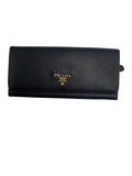 Front view of a Prada Saffiano leather continental flap wallet in black with gold-tone Prada Milano logo lettering