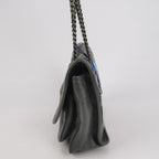 Grey saint laurent handbag with a chain strap on a light gray background