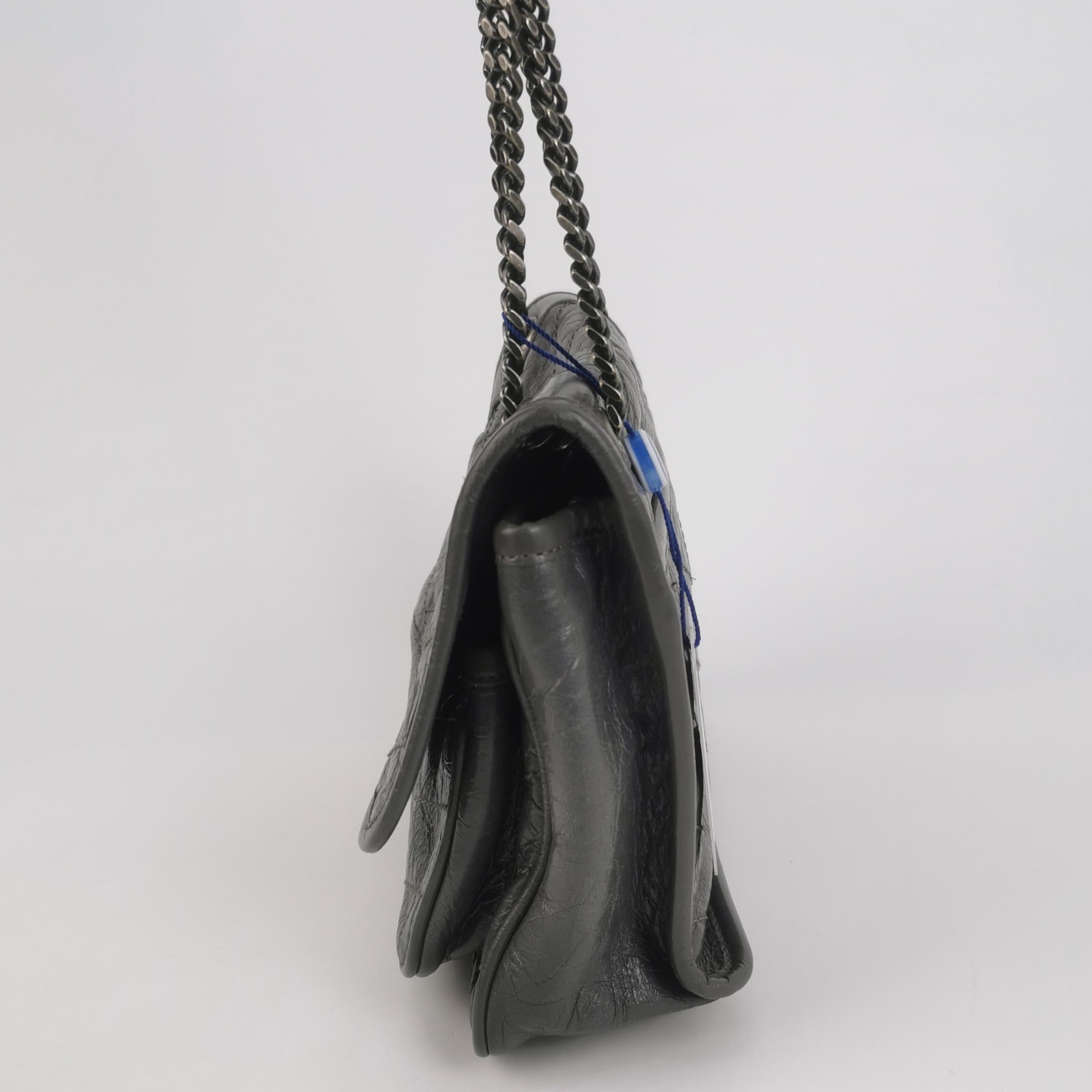 Grey saint laurent handbag with a chain strap on a light gray background